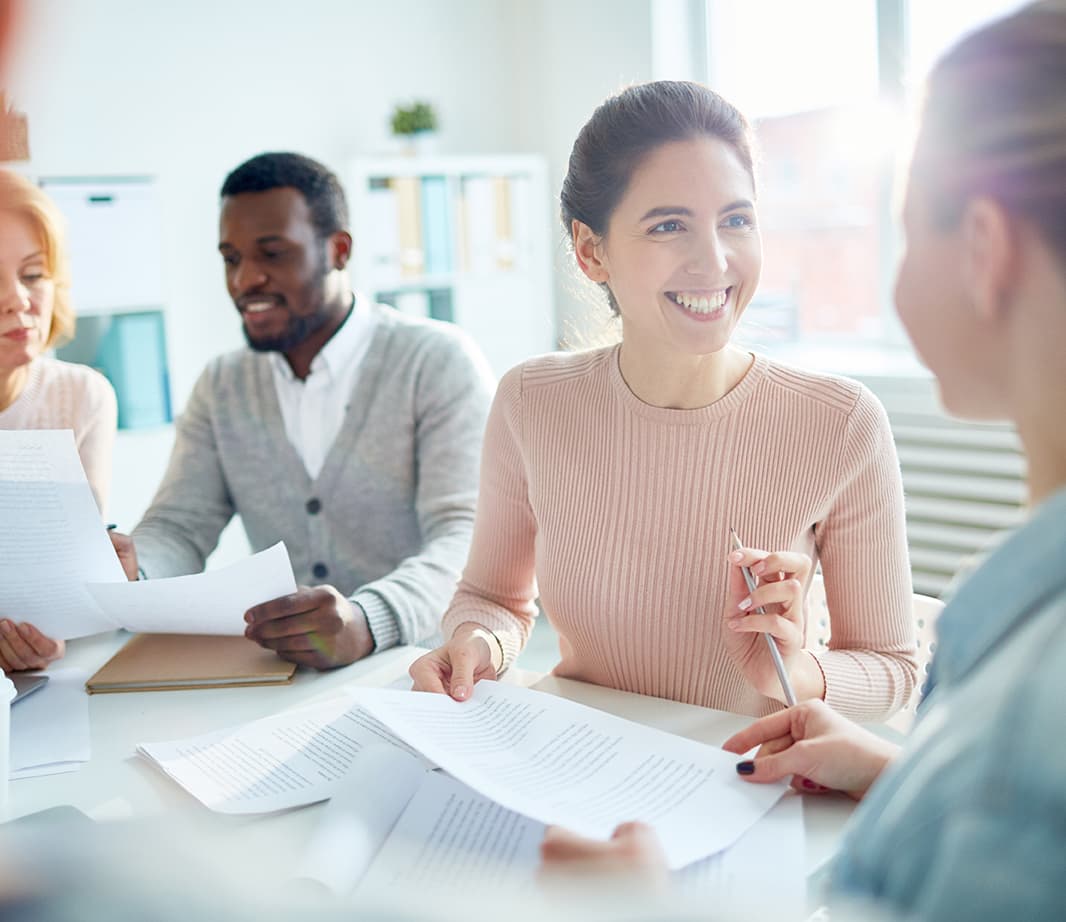 Smiling woman in meeting with 3 other people